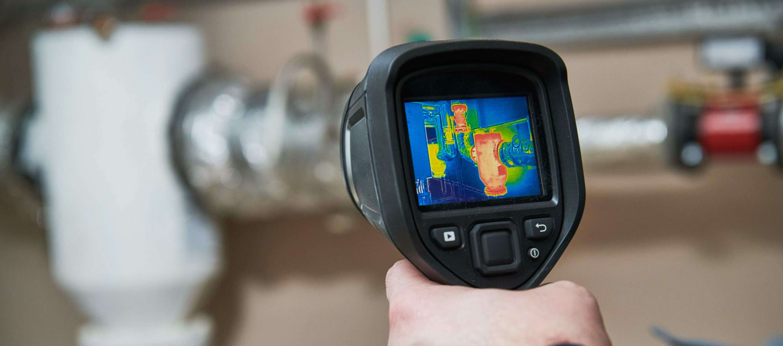 Handheld infrared camera reading a roof assembly
